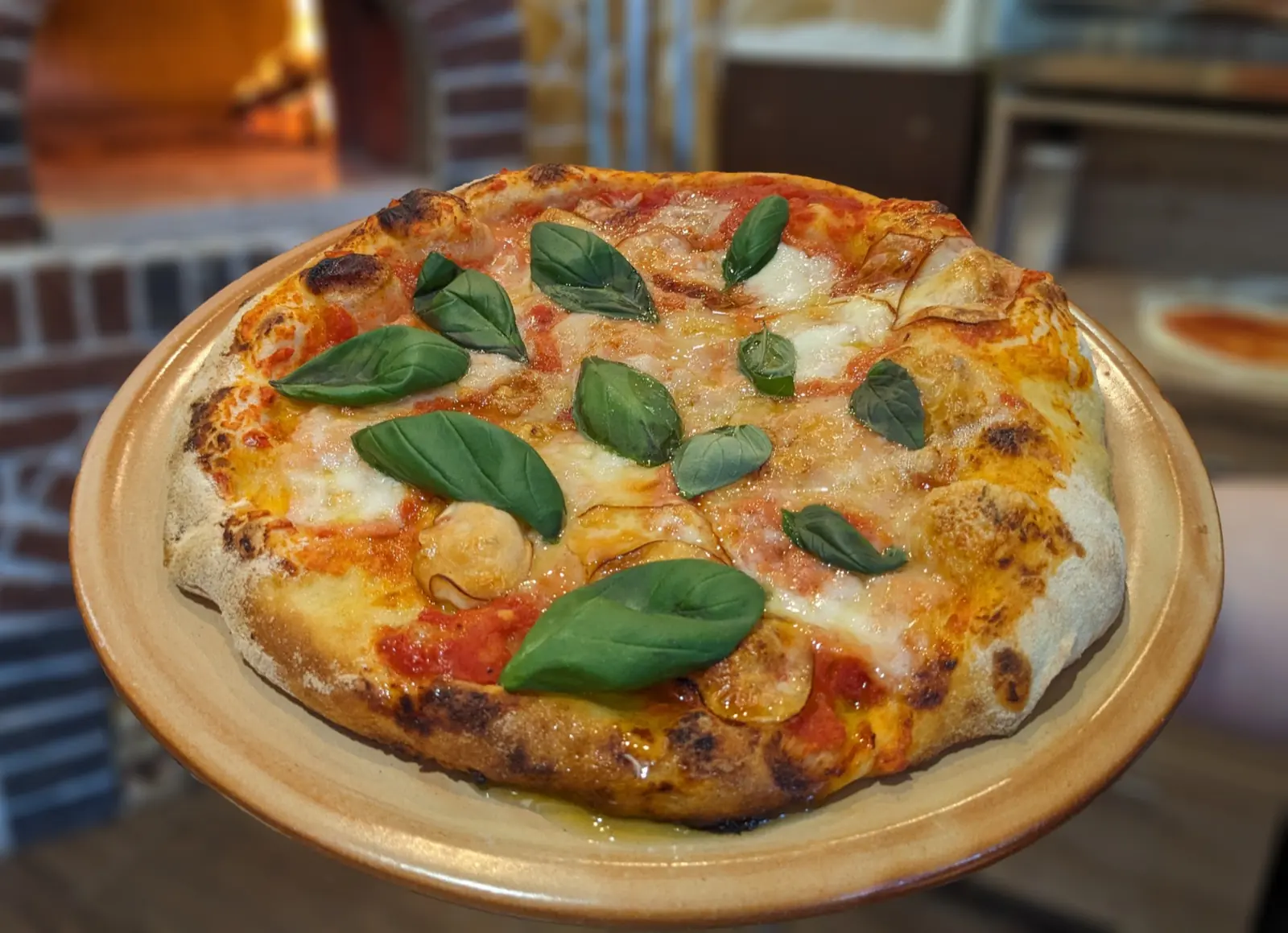 Margherita na talíři před kamennou pecí